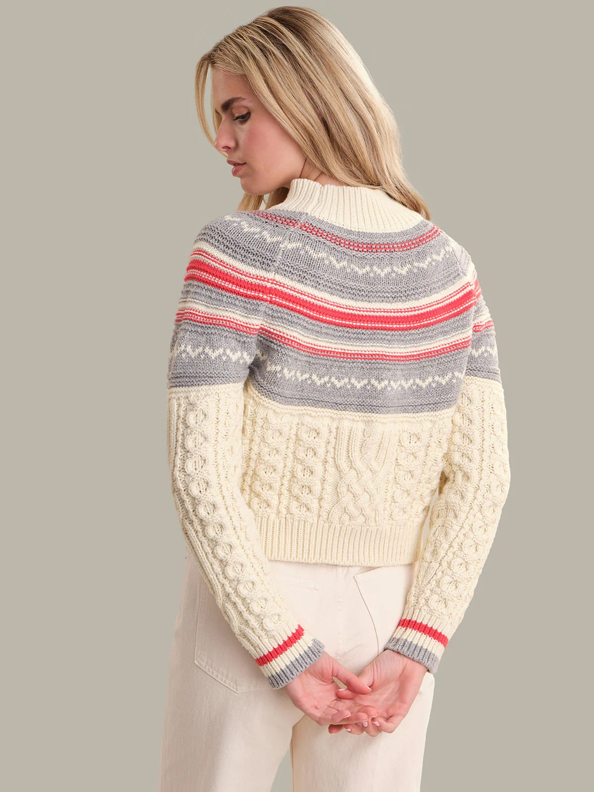 Woman wearing a patterned sweater with a neutral background