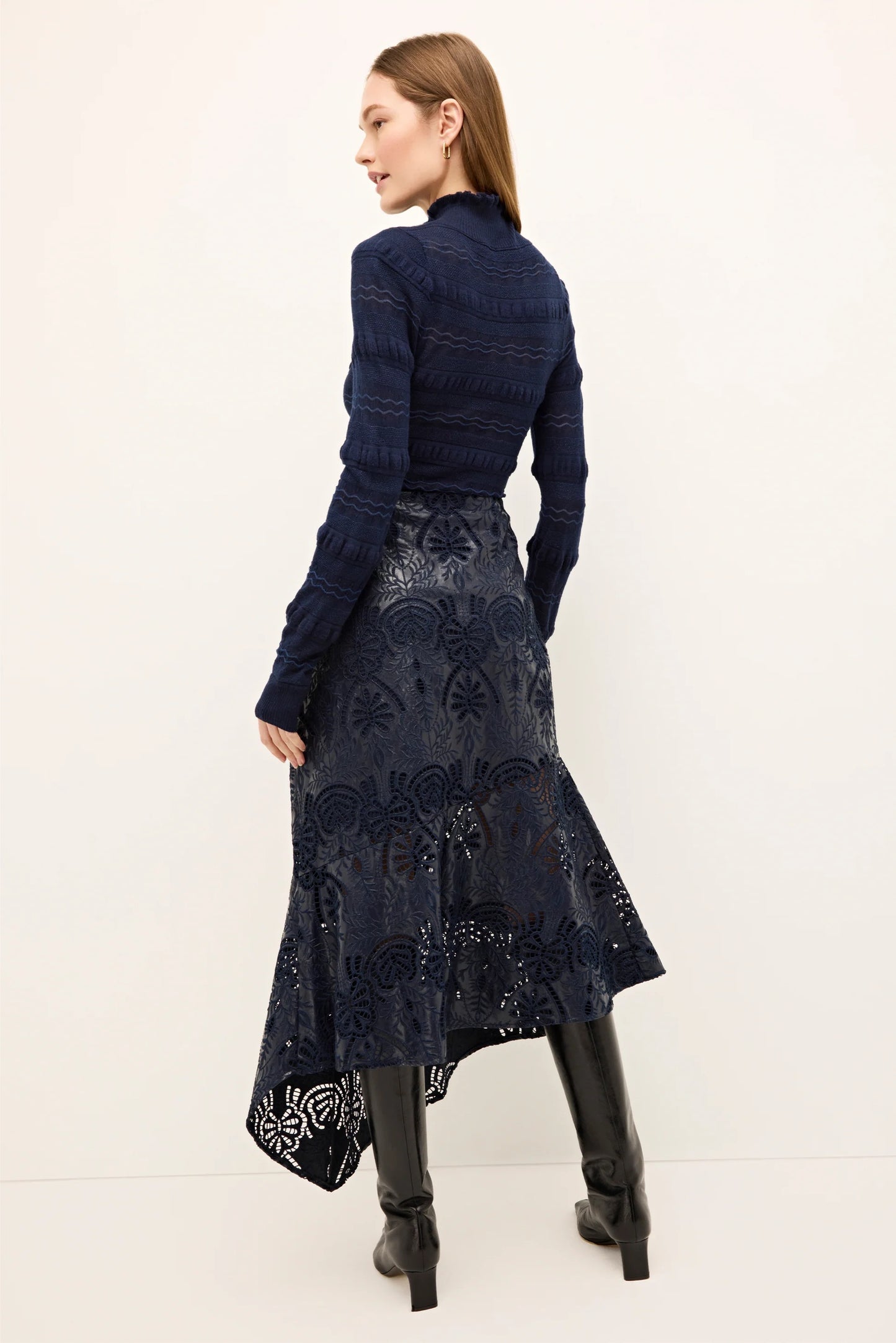 Woman wearing a dark blue patterned dress with a white background