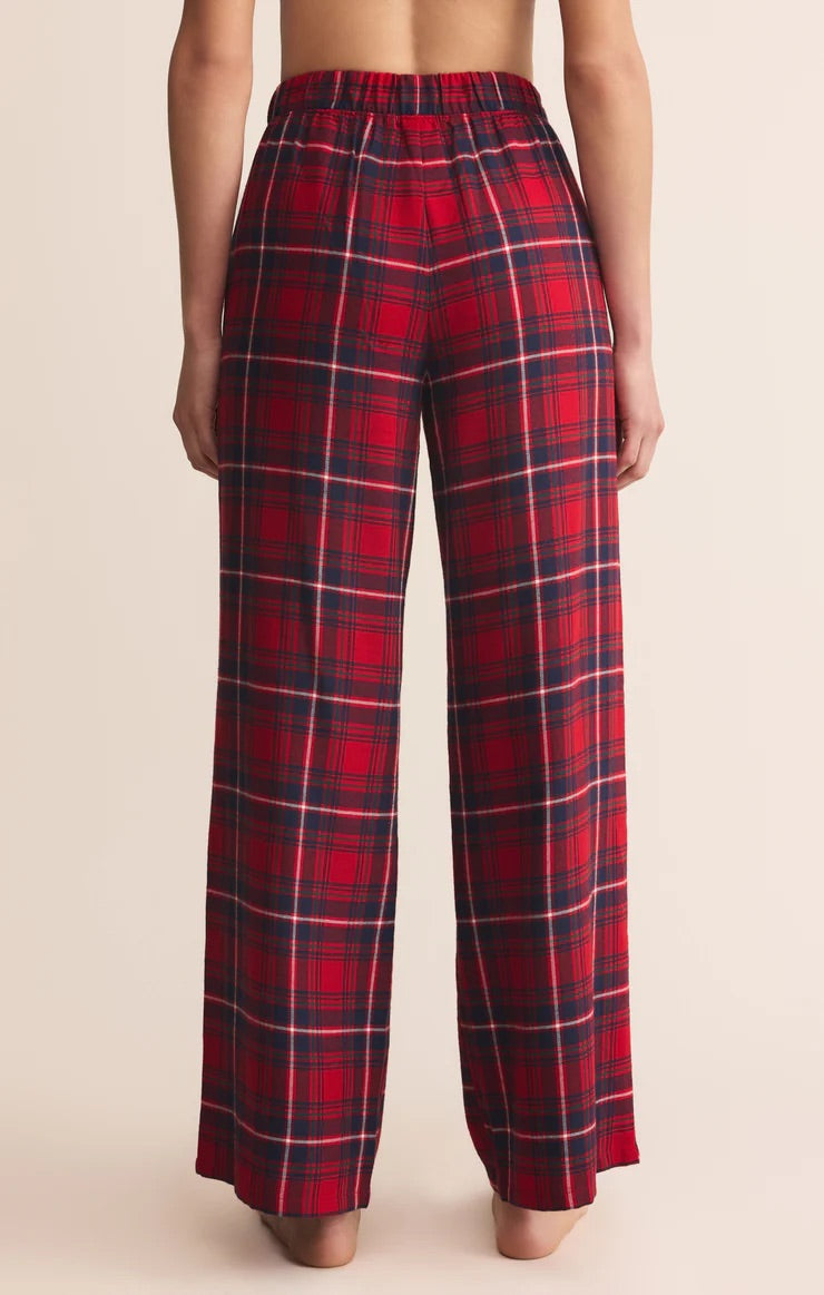 Red plaid pants worn by a person on a beige background