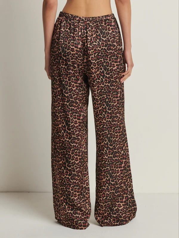 Leopard print pants worn by a person on a plain background