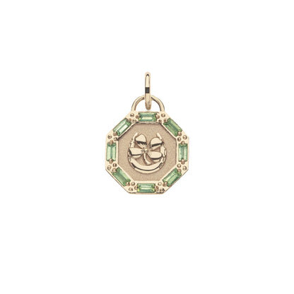 Gold pendant with a clover design and green gemstones on a white background