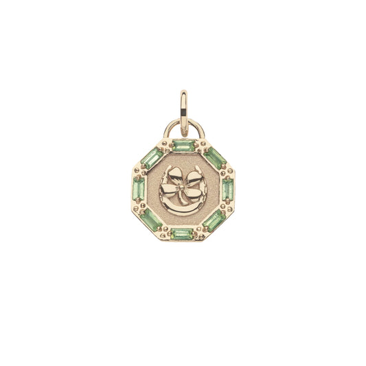 Gold pendant with a clover design and green gemstones on a white background