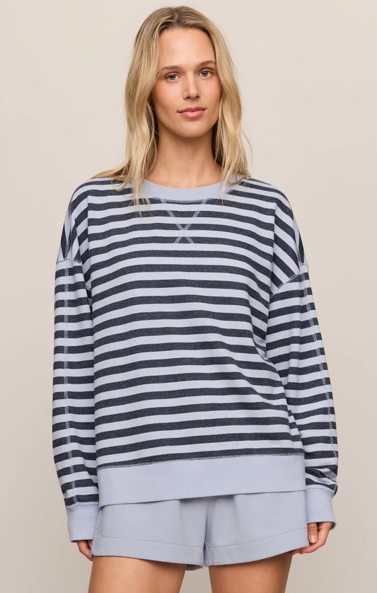 Woman wearing a striped sweater and shorts on a plain background
