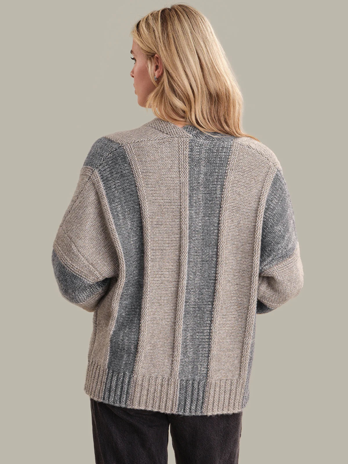 Woman wearing a striped sweater with a neutral background