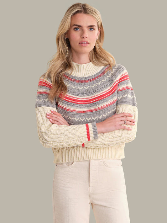 Woman wearing a patterned sweater with a neutral background