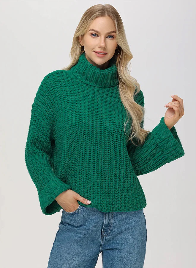 Woman wearing a green knitted sweater and blue jeans on a white background