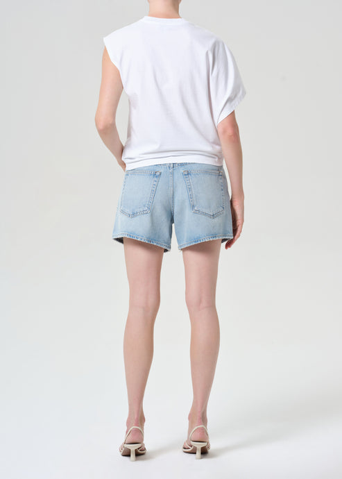 Person wearing light blue denim shorts and a white t-shirt on a plain background