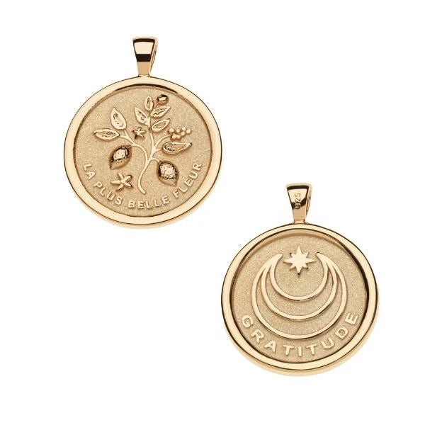 Two gold pendants with engraved designs on a white background