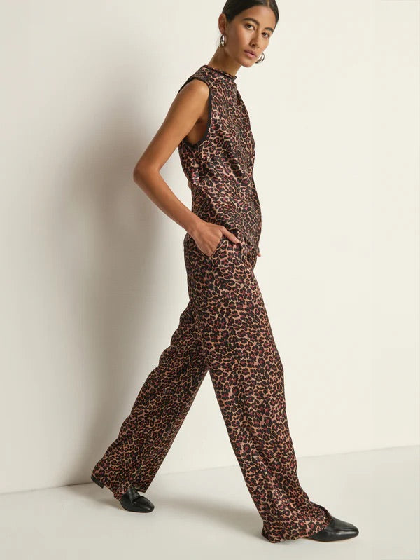 Woman wearing a leopard print jumpsuit against a plain background