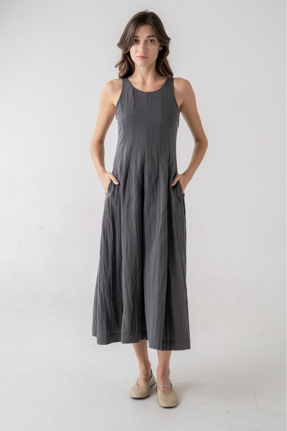 Woman wearing a gray sleeveless dress on a white background