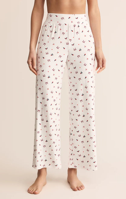 White pajama pants with a subtle pattern worn by a person on a beige background