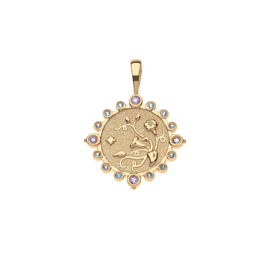 Gold pendant with intricate design and colorful stones on a white background