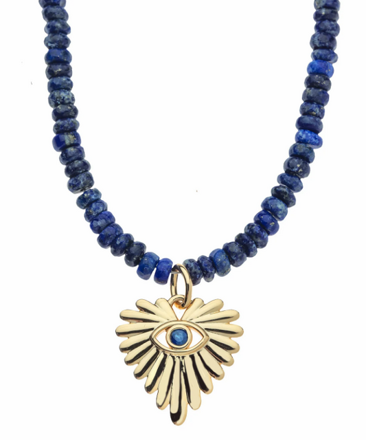 A beaded necklace featuring dark blue lapis lazuli beads and a gold-toned evil eye pendant with a blue stone center, shown against a plain white background.