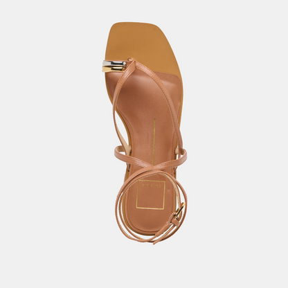 Tan sandal with thin straps on a light gray background