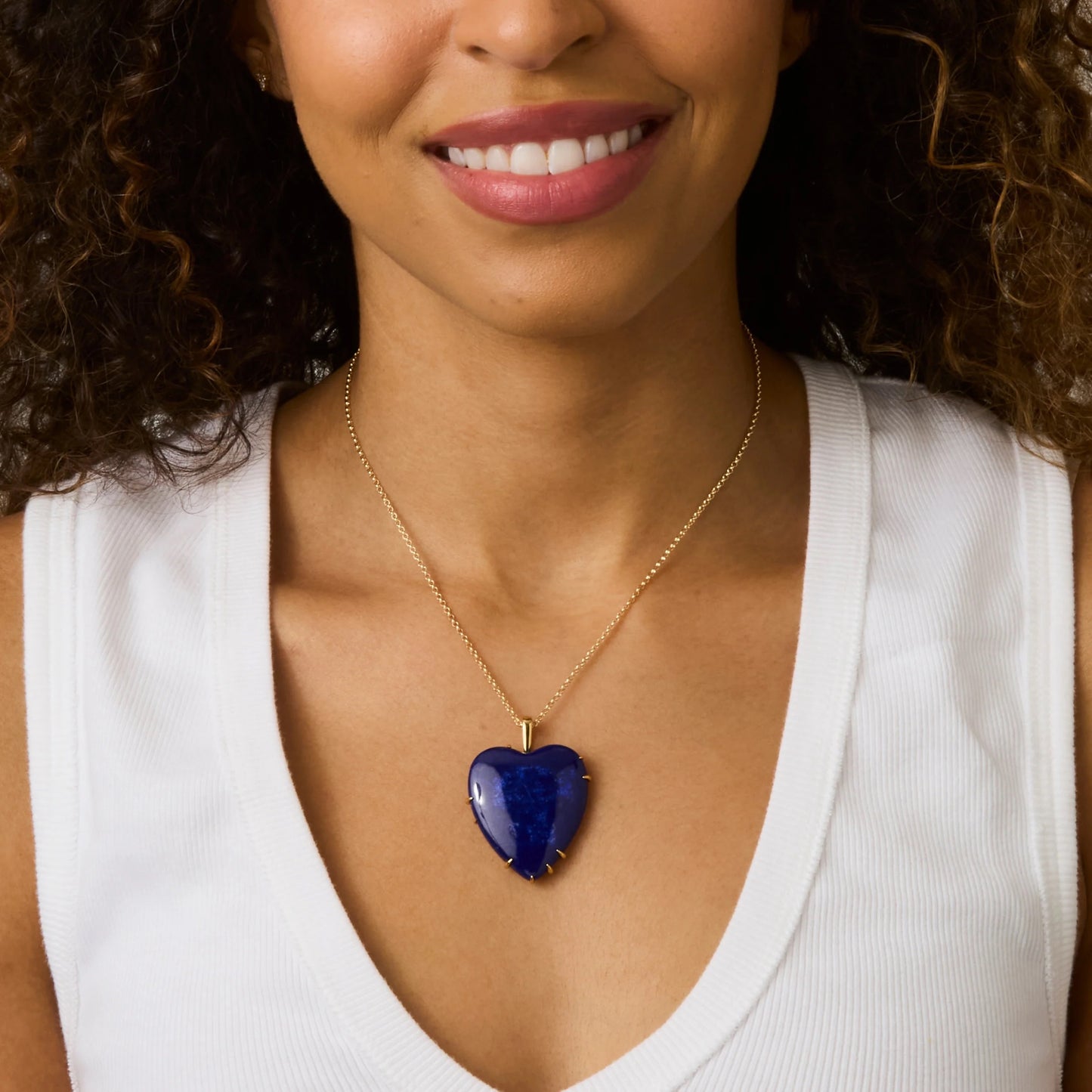 Woman wearing a necklace with a blue heart pendant