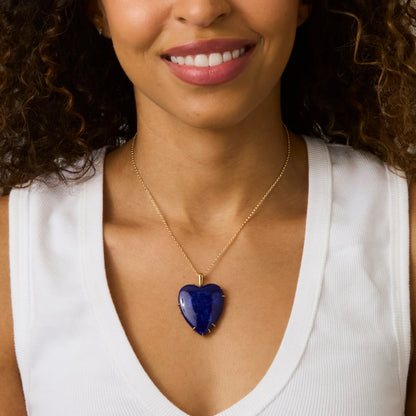 Woman wearing a necklace with a blue heart pendant