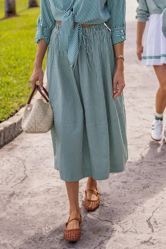 Two women walking on a sidewalk, both wearing light green outfits.