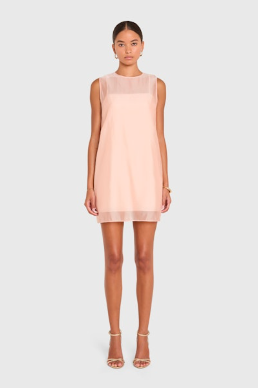 Woman wearing a light pink dress on a white background