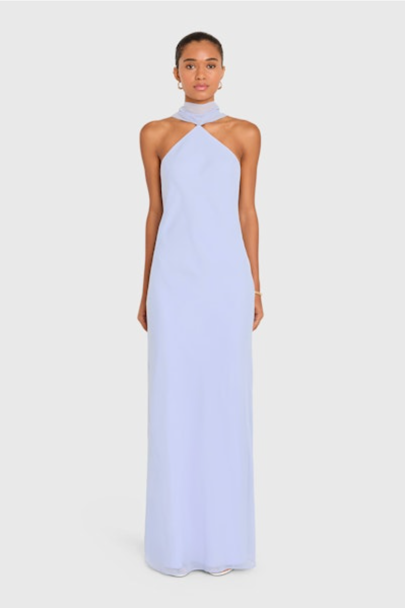 Woman wearing a light blue halter neck gown on a white background