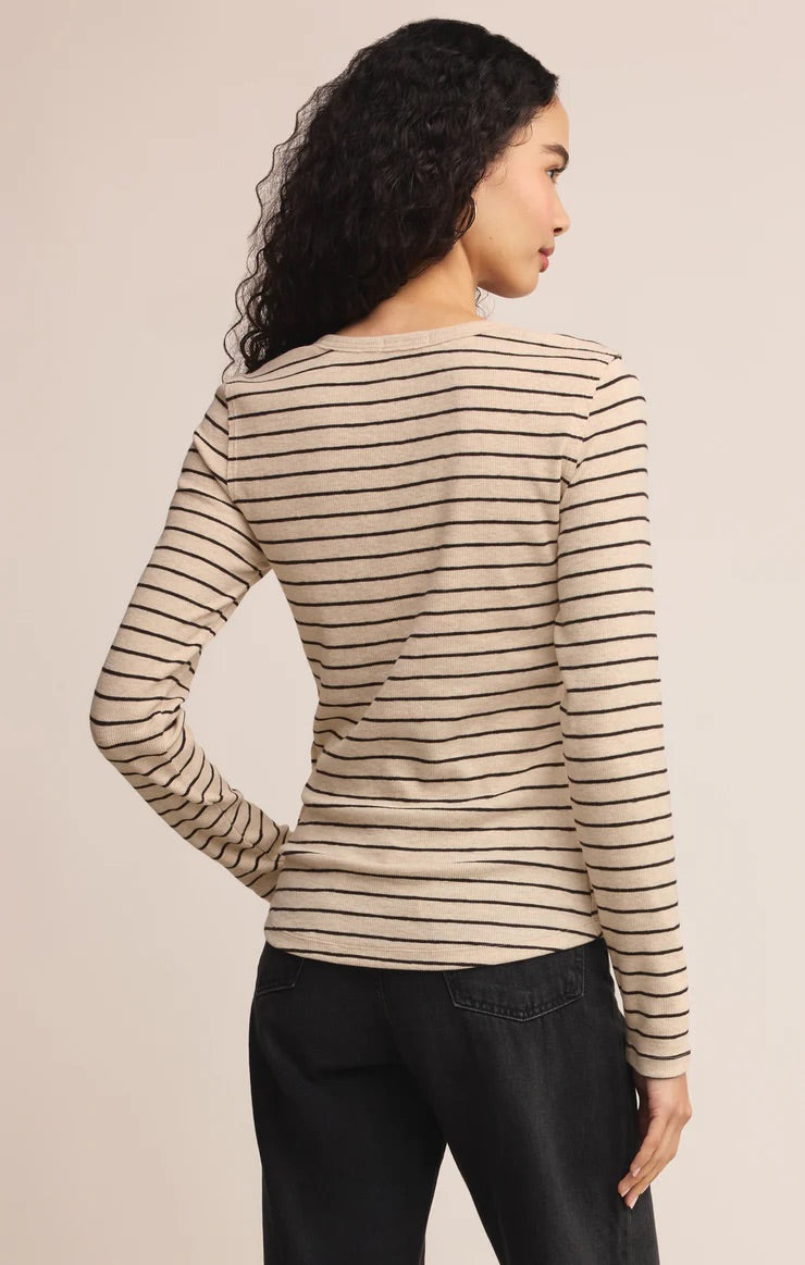 women in stripped henley shirt posed in front of a beige background