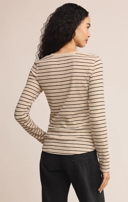 women in stripped henley shirt posed in front of a beige background