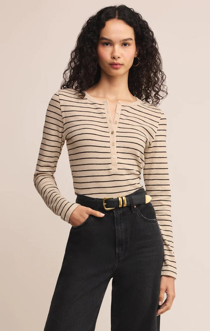 women in stripped henley shirt posed in front of a beige background