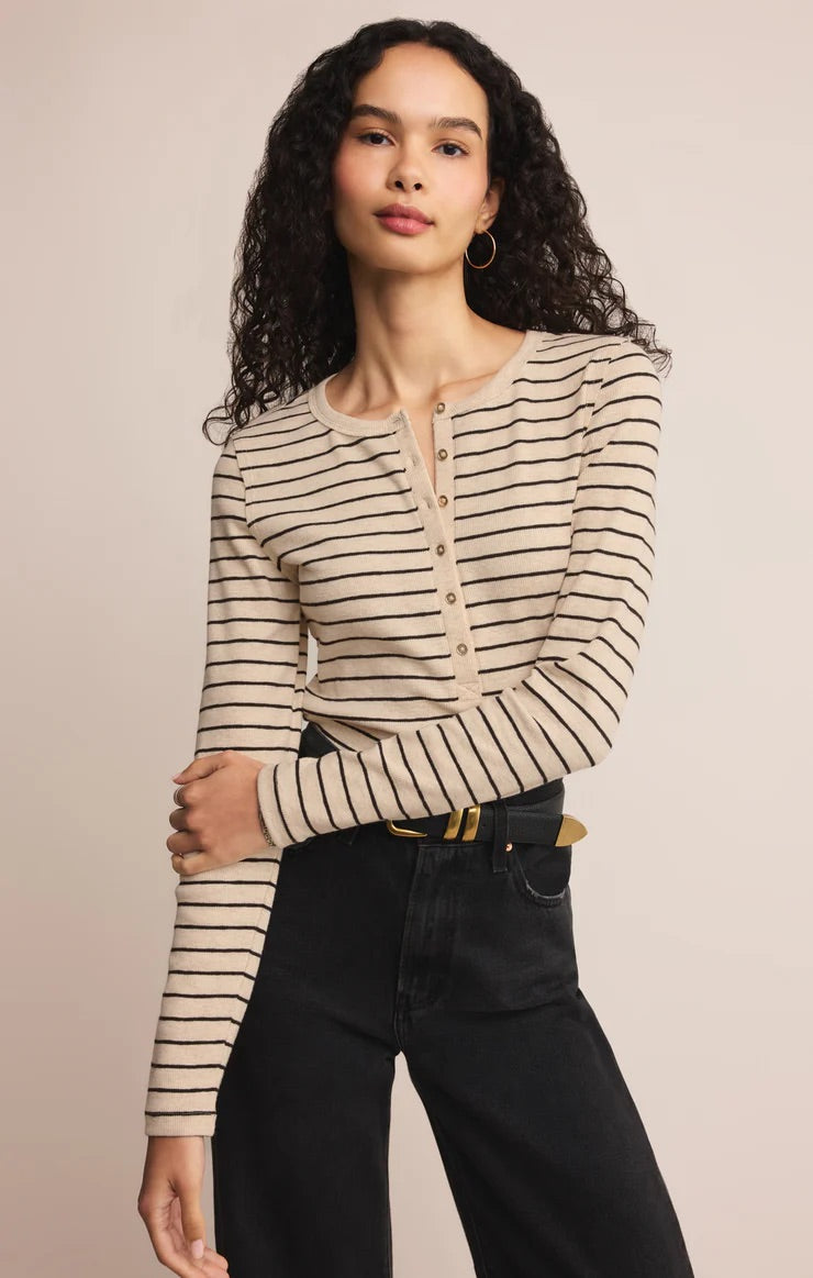 women in stripped henley shirt posed in front of a beige background