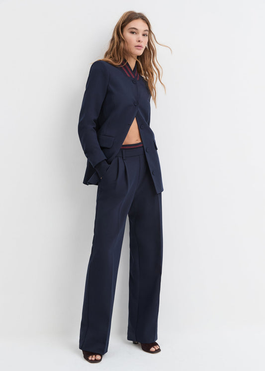 Woman wearing a navy blue suit against a white background