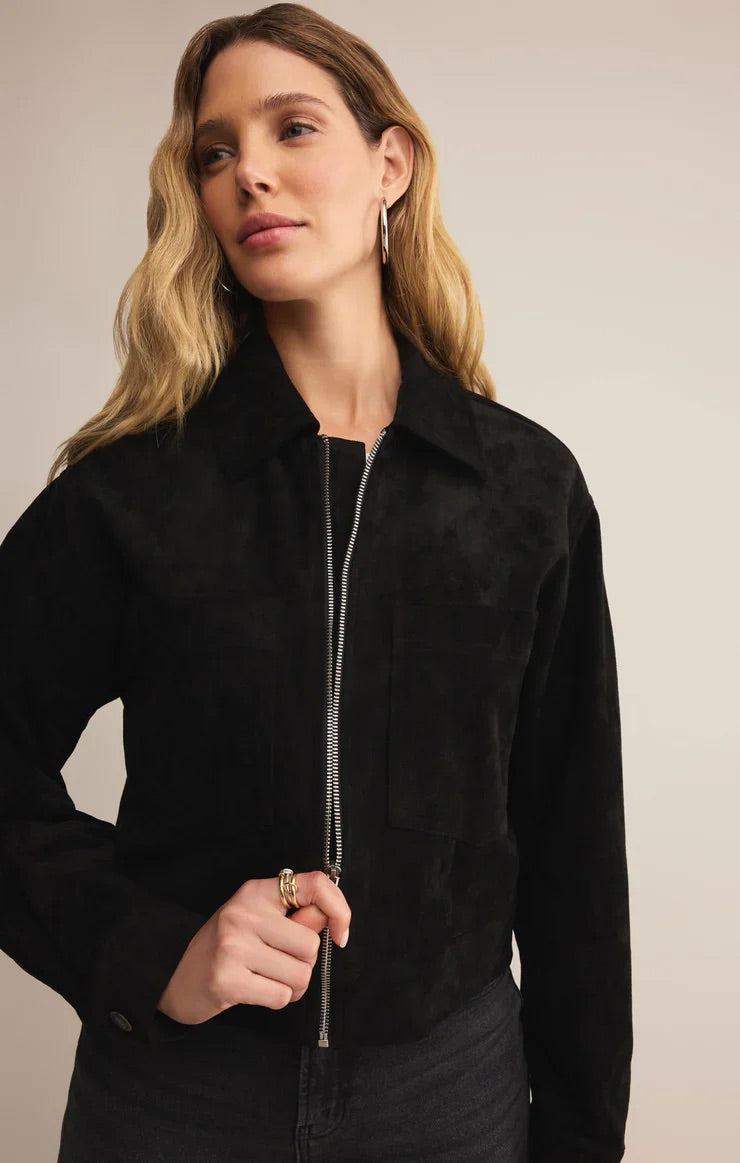 Woman wearing a black jacket with a neutral background