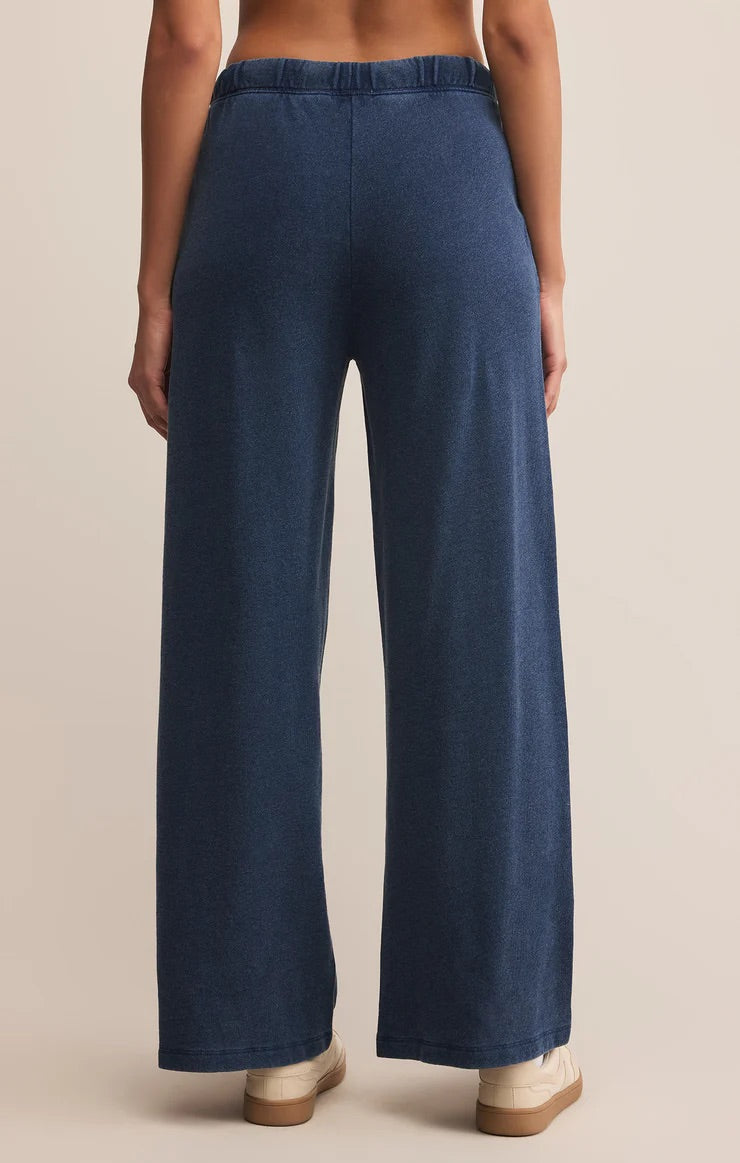 Woman wearing a blue sweatpants on a beige background