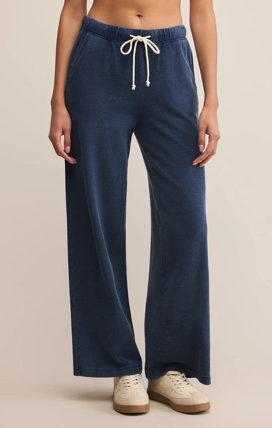 Woman wearing a blue sweatpants on a beige background