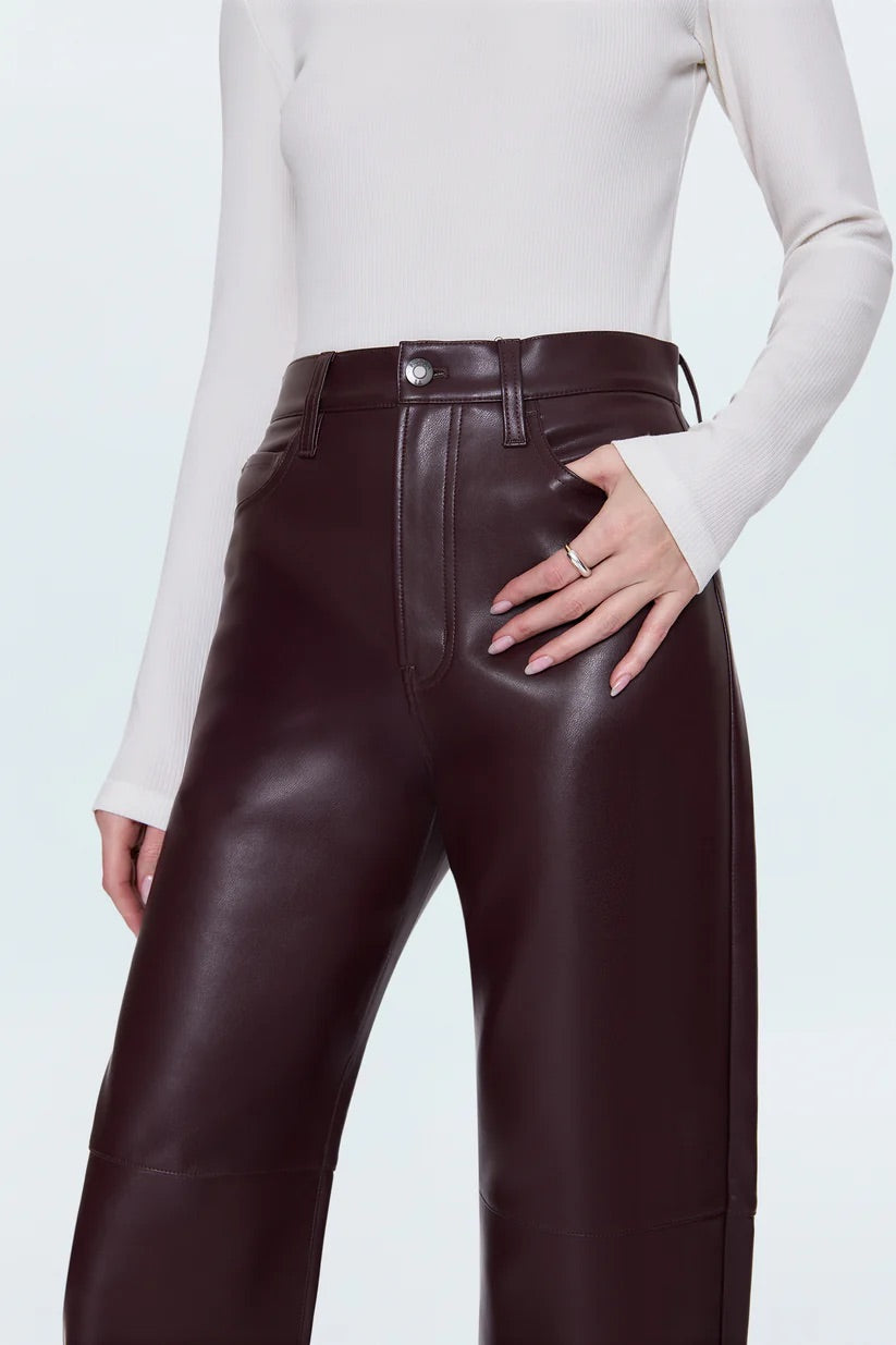 Merlot leather pants worn by a person on a light blue background