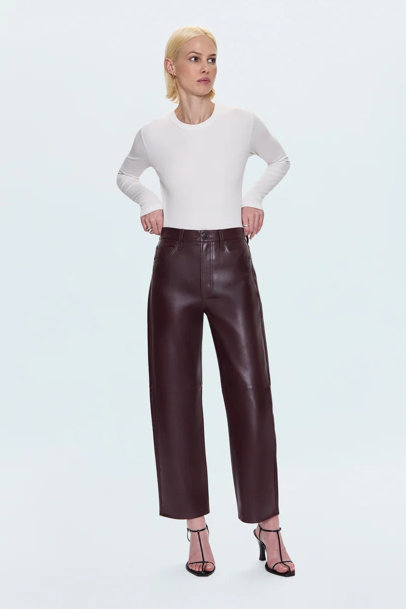 Merlot leather pants worn by a person on a light blue background