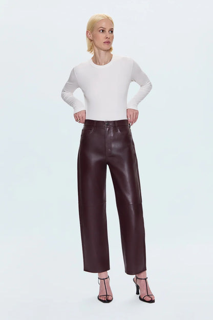 Merlot leather pants worn by a person on a light blue background