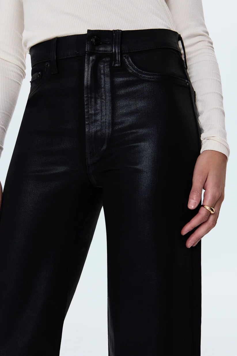 Person wearing black leather pants with a white background