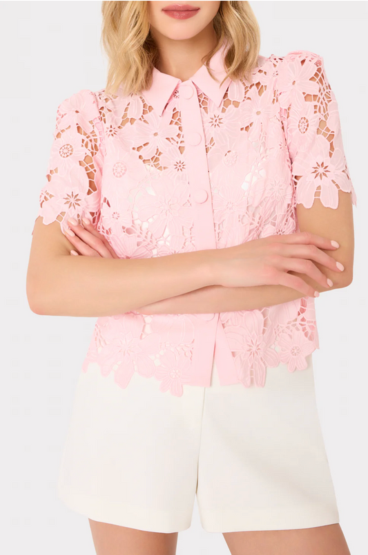 Person wearing a pink lace blouse with a white background