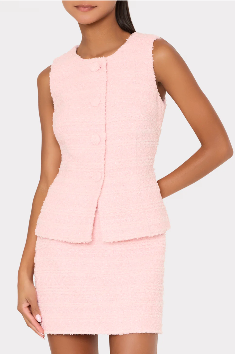 Woman wearing a light pink dress with a textured pattern on a white background