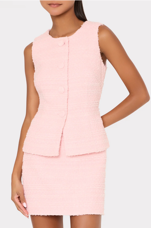 Woman wearing a light pink dress with a textured pattern on a white background