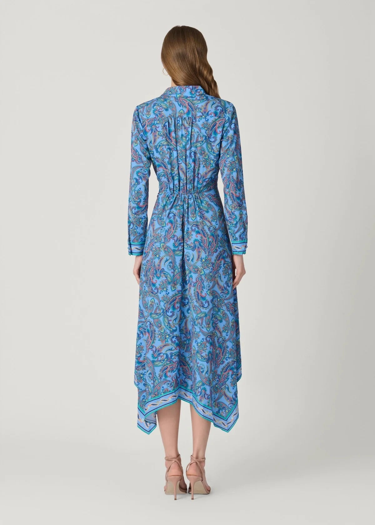 Woman wearing a blue patterned dress on a white background