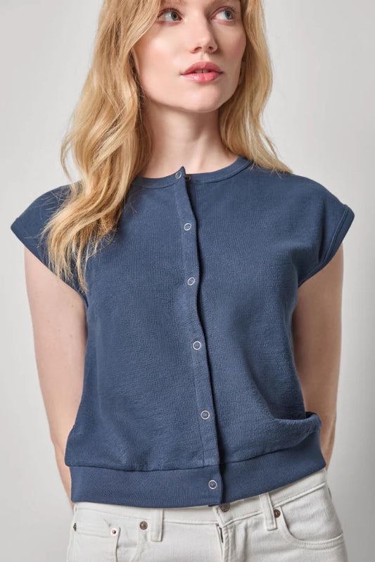 Woman wearing a blue sleeveless top against a plain background