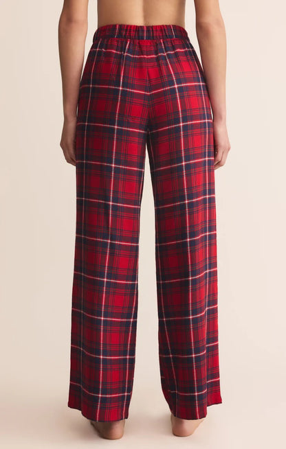 Red plaid pants worn by a person on a beige background