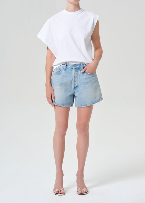Person wearing a white t-shirt and light blue denim shorts on a white background