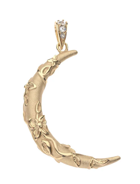 A gold crescent moon pendant with embossed floral and leaf details, featuring a small clear gemstone in the bail, shown on a plain white background.