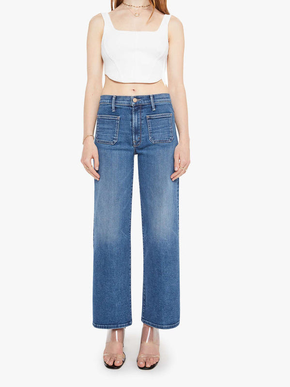 Woman wearing blue jeans and a white top on a white background