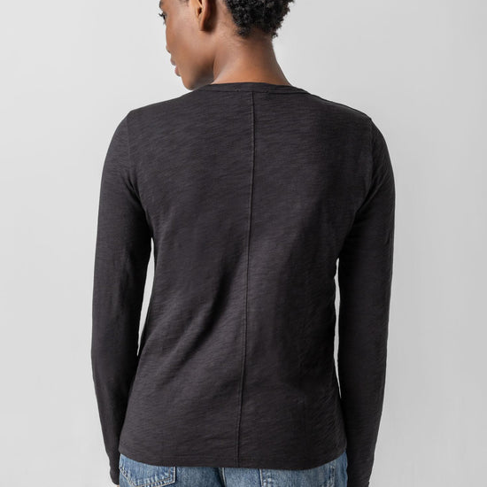 Person wearing a dark gray long-sleeve shirt on a light gray background