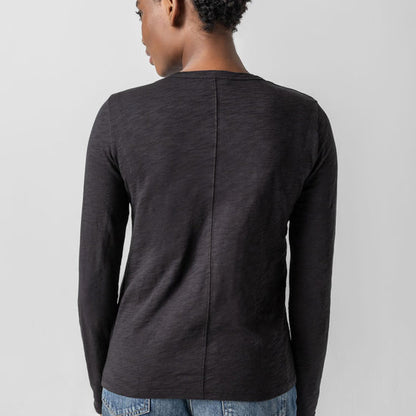 Person wearing a dark gray long-sleeve shirt on a light gray background