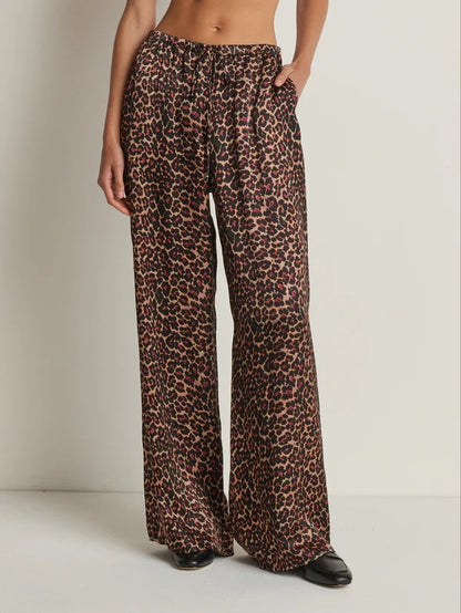 Leopard print pants worn by a person on a plain background