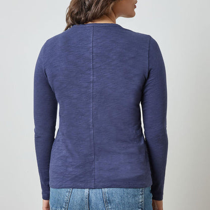 Person wearing a blue long-sleeve shirt against a plain background