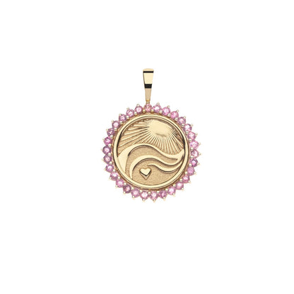 A round gold pendant featuring a stylized sun and moon design with a small heart, surrounded by a border of pink gemstones, shown on a plain white background.