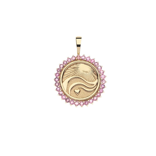 A round gold pendant featuring a stylized sun and moon design with a small heart, surrounded by a border of pink gemstones, shown on a plain white background.